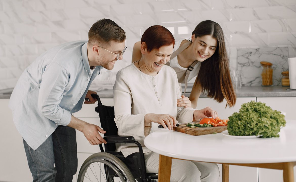 Support workers preparing a meal with a woman who uses a wheelchair